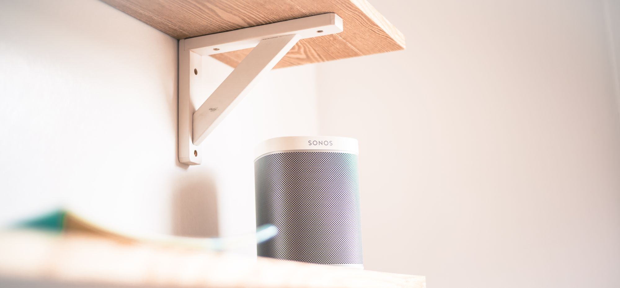 A Sonos Play One device under a shelf